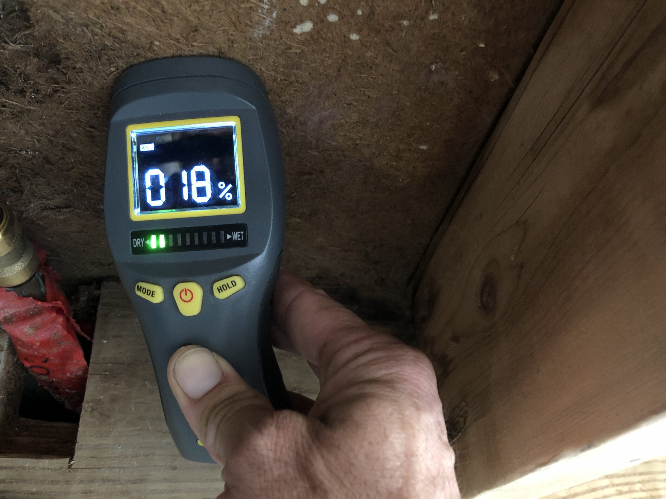 moisture meter being used to detect moisture in construction materials.